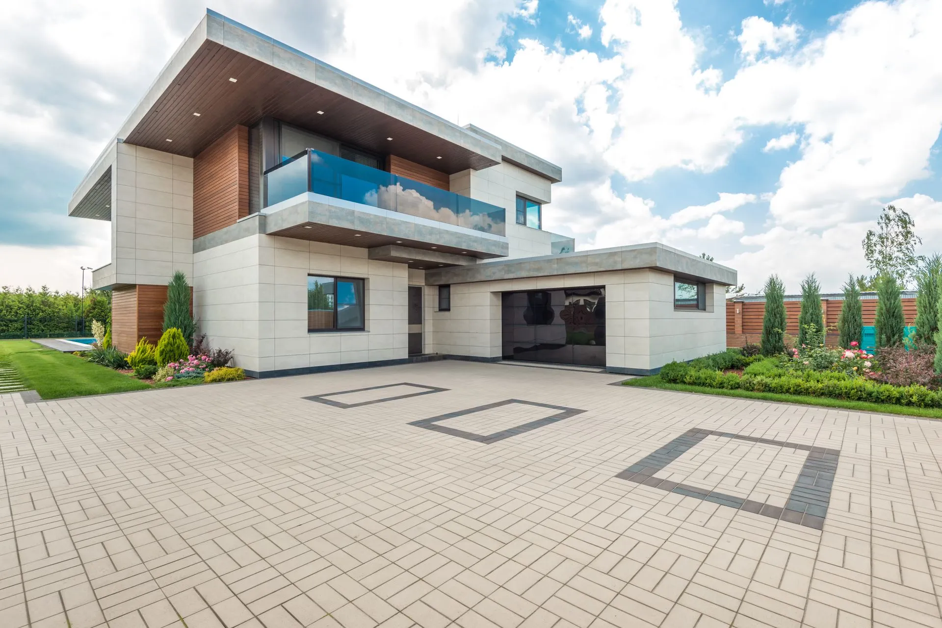 Spotless light-colored paver driveway in front of a modern home